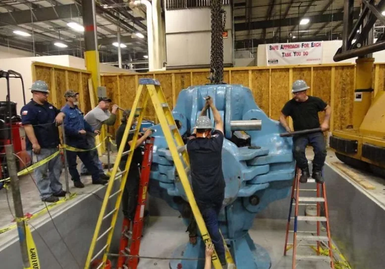 Technicians installing a six-sided cubic hydraulic press